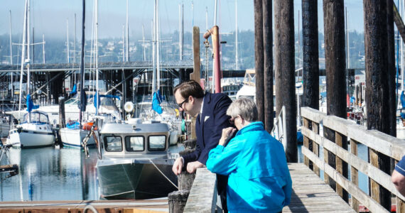 Councilmembers Bryan Stucky and Barbara Armes watch a seal at the Oak Harbor marina. (Photo by Sam Fletcher)