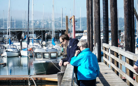 Councilmembers Bryan Stucky and Barbara Armes watch a seal at the Oak Harbor marina. (Photo by Sam Fletcher)