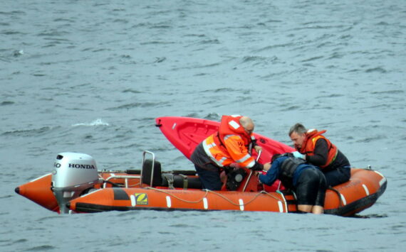 Photo provided
Washington State Ferries crew members help a kayaker in distress climb aboard their rescue vessel Sunday.