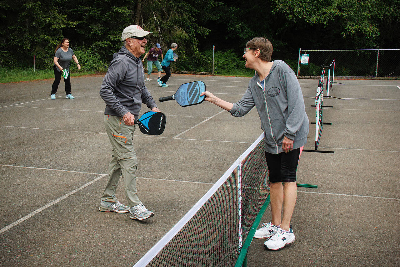 (Photo by David Welton)
Pickleball players Steve Eldridge and Lee Benner meet on the temporary courts at the South Whidbey Sports Complex.