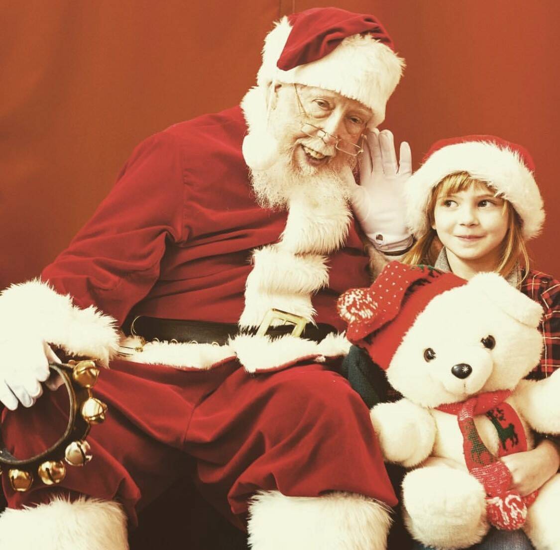 (Photo provided)
Santa leans in to hear a child as she holds Gracie the polar bear. The Greenbank Farm’s Santa Claus learned the art of bringing the legendary figure to life at a Santa school in Colorado.