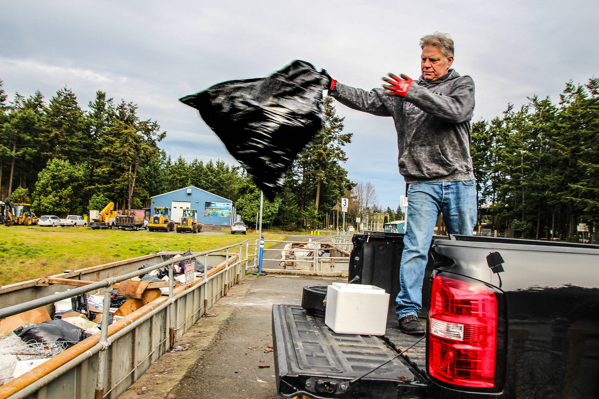 (Photo by Ian Tiessen)
Jeff Frey throws a trash bag into the dump at the Island County Solid Waste Complex.